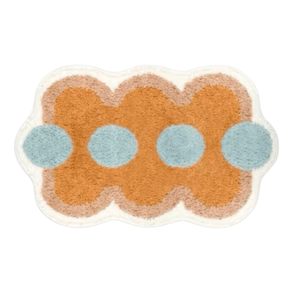 A plush orange funky shaped bath mat with wavy edges light blue circular accents and a soft beige border