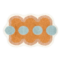 A plush orange funky shaped bath mat with wavy edges light blue circular accents and a soft beige border