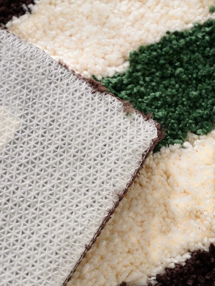 Back side of a retro checkered plaid rug in cream and green with a textured woven backing and dark brown accents