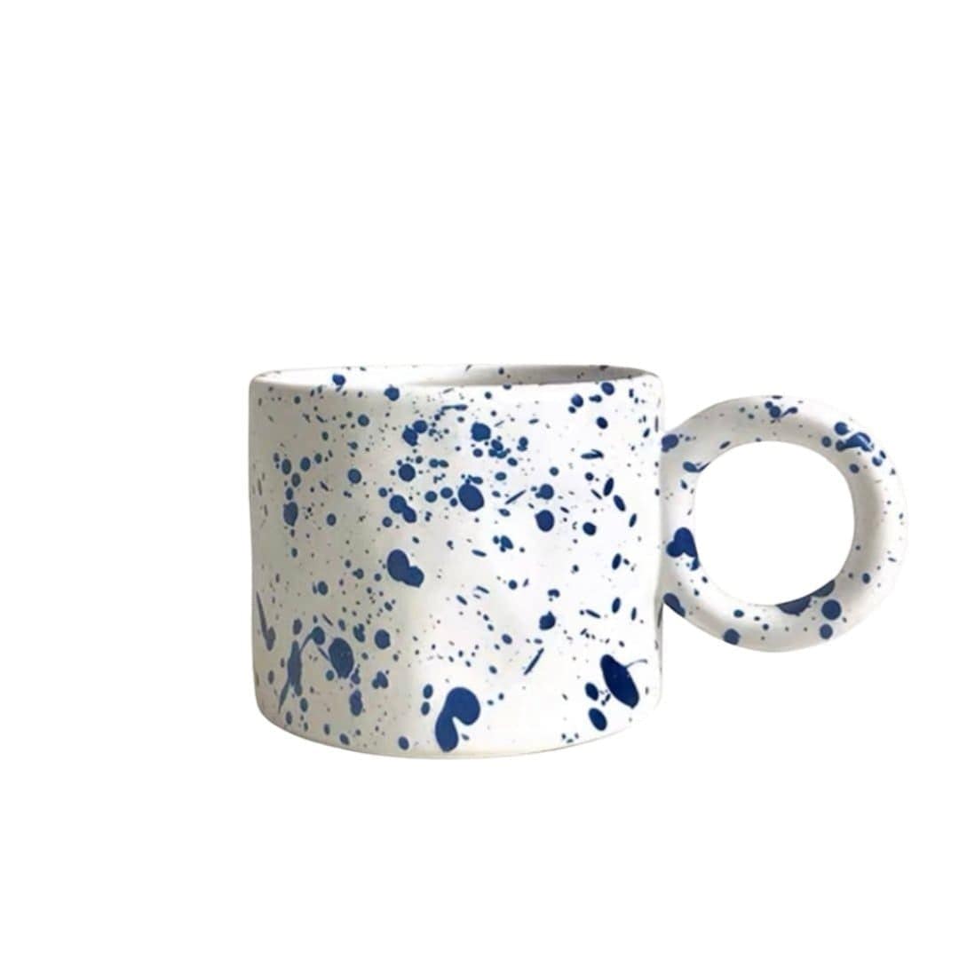 White ceramic Dumbo mug with speckled blue splatter pattern and circular handle for everyday use