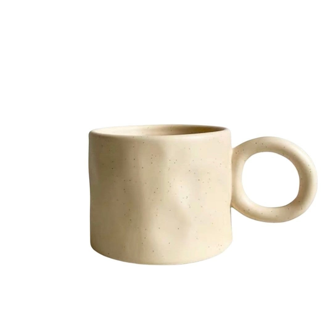 Cream-colored ceramic dumbo mug with a textured speckled finish and minimalist circular handle for drinking