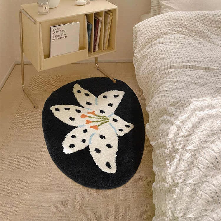 Round black rug with white floral design in a bedroom setting