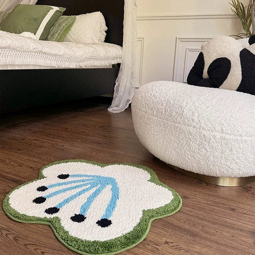 Black flower shaped plush rug with white center, light blue lines, black dots, and green fringe border