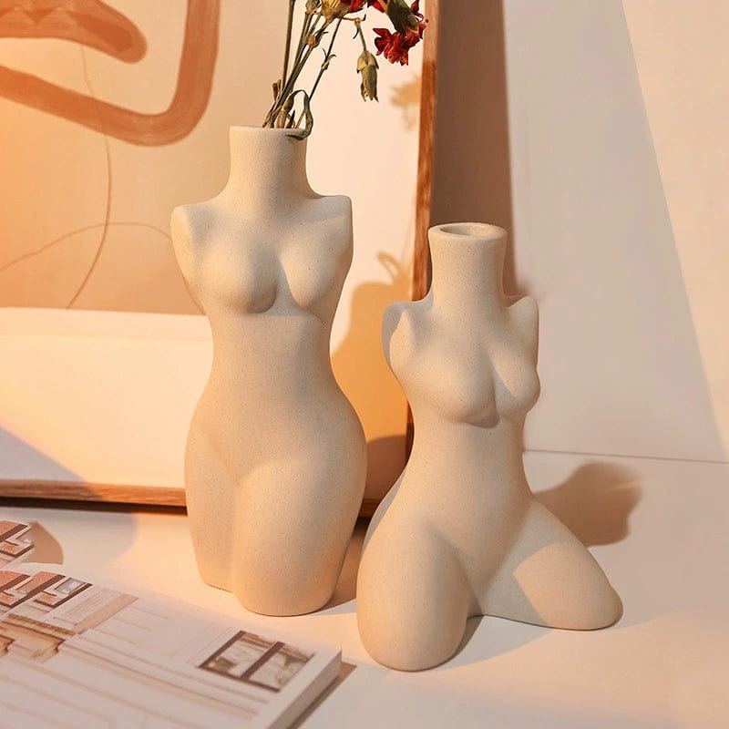 Two beige ceramic body shaped vases featuring female torsos one standing upright and one kneeling for home decor