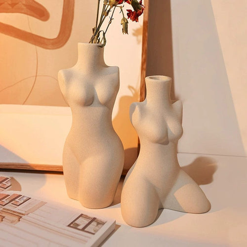 Two beige ceramic body shaped vases featuring female torsos one standing upright and one kneeling for home decor