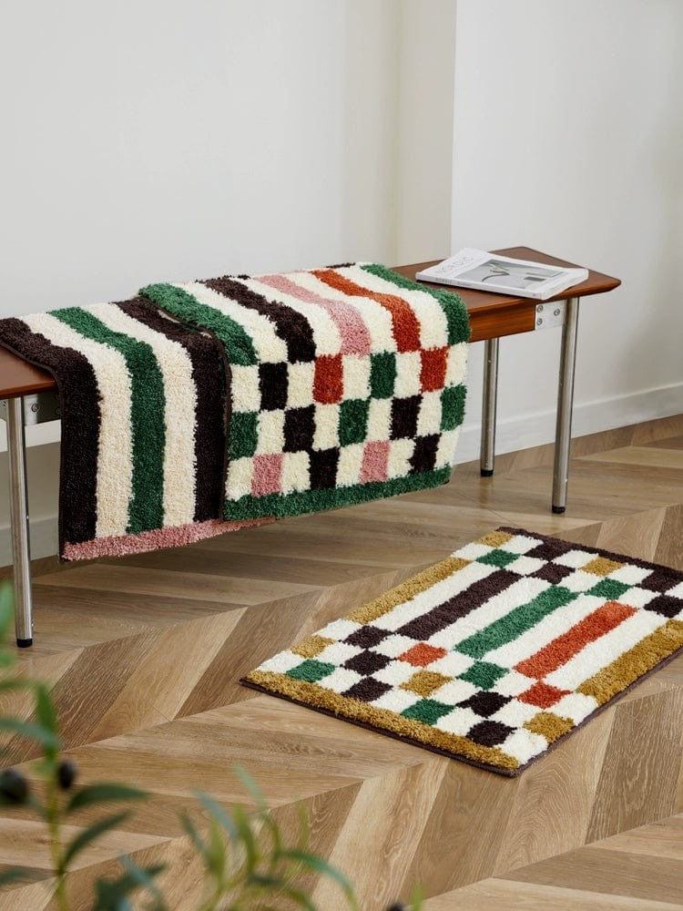 A plush retro checkered plaid bath mat with shaggy texture in green dark brown multicolored stripes and checks