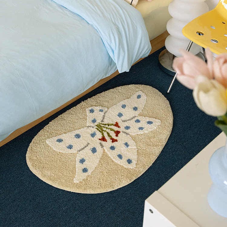 Decorative rug with floral design on a dark floor next to a bed.
