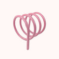 Pink spiral metal spring book holder designed as a bike rack for holding books securely and stylishly