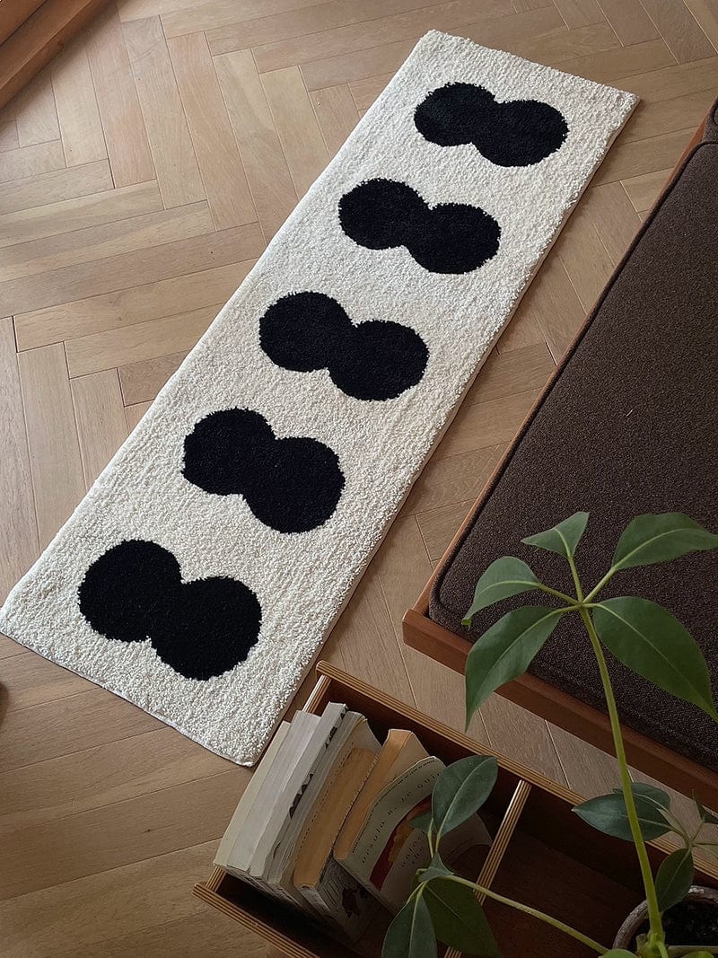 Minimal runner rug cream-colored plush with five bold black rounded 8 shapes arranged vertically