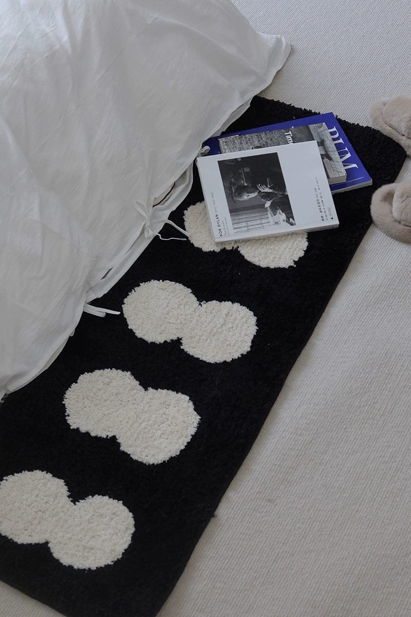 Minimal runner rug featuring plush white cloud-like patterns on a black soft textured surface