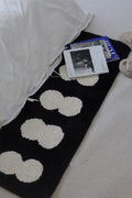 Minimal runner rug featuring plush white cloud-like patterns on a black soft textured surface