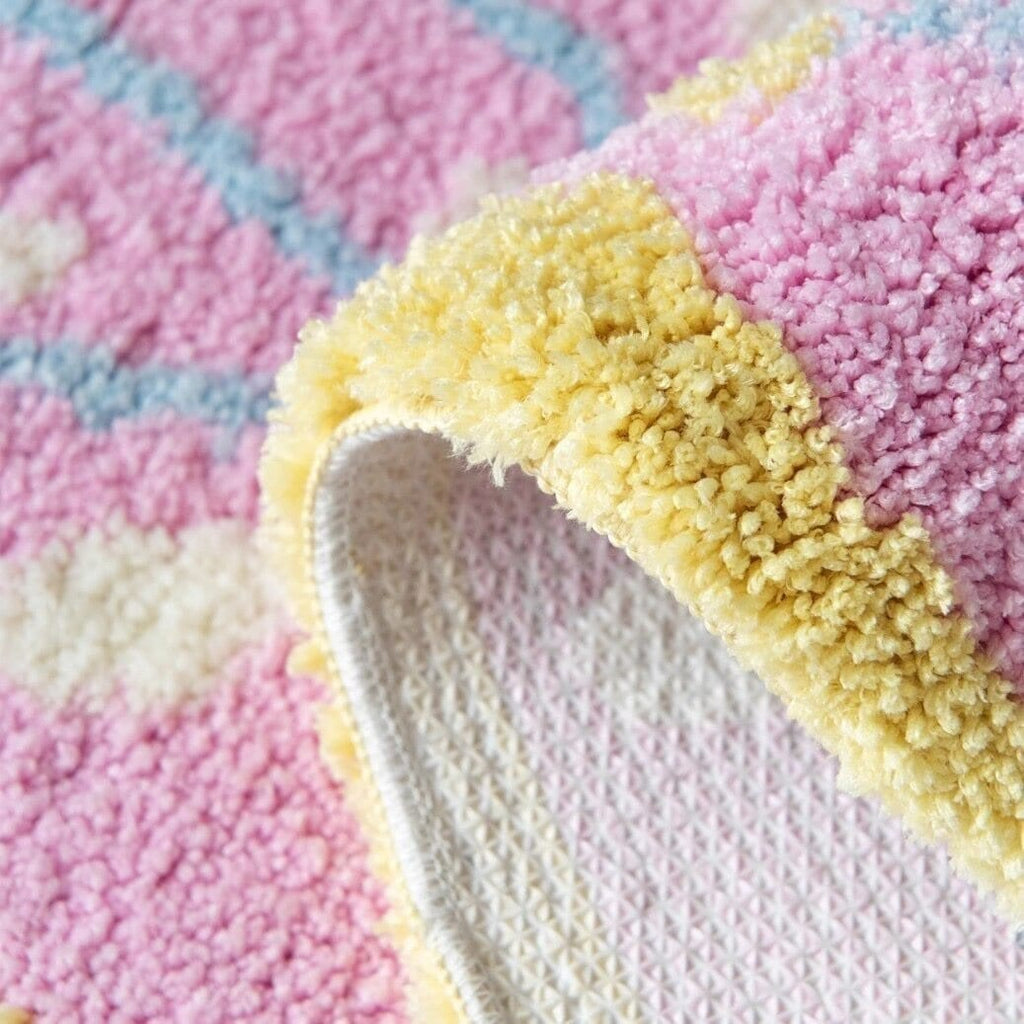 Pink leaf shaped rug with soft textured surface in pastel pink yellow and blue plush material