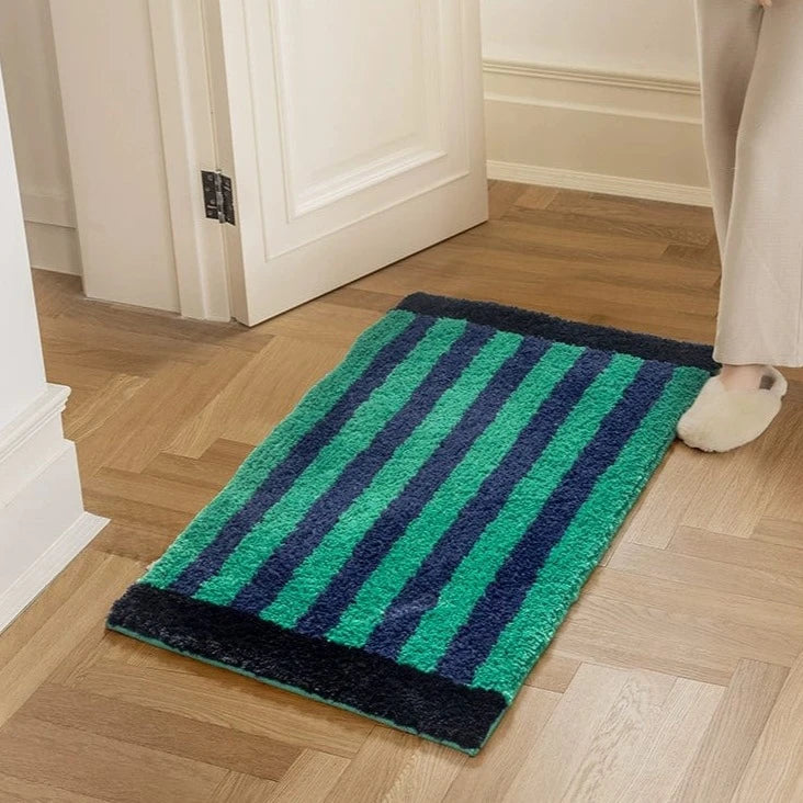 Green retro striped bath mat with plush rectangular shape soft textured surface in vibrant green and deep navy blue stripes