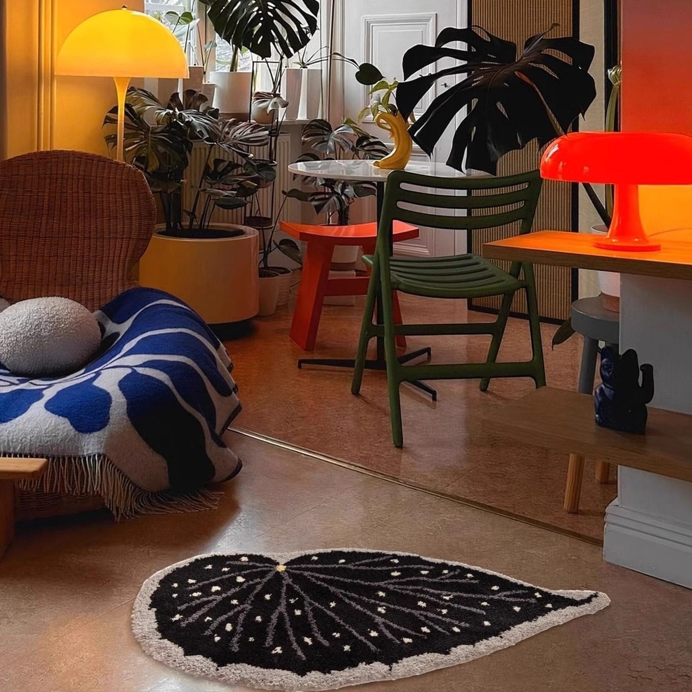 Modern interior with a black and white rug, green chair, and colorful furniture.