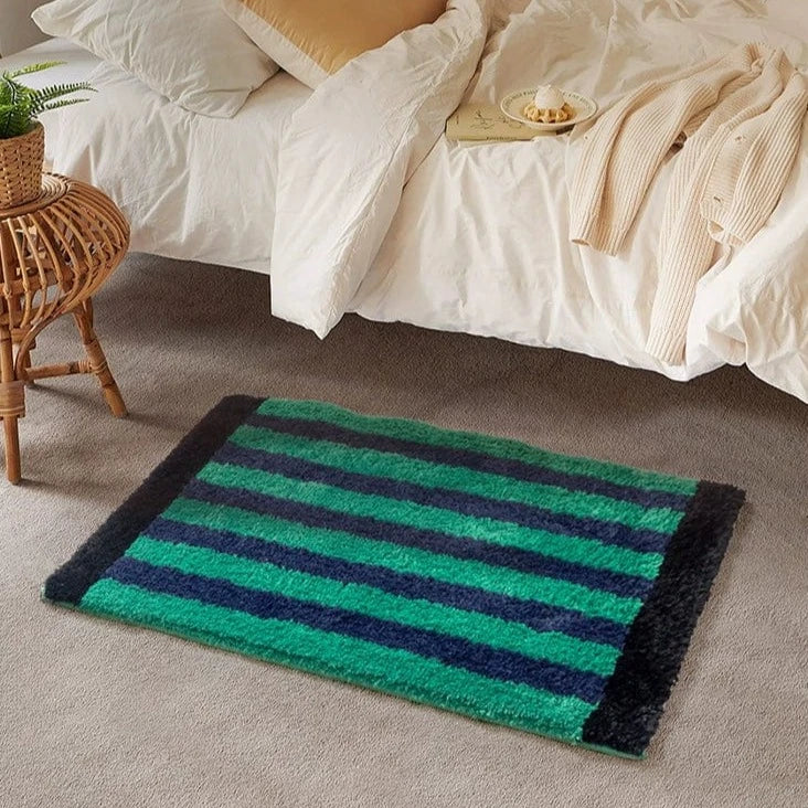 Green retro striped bath mat plush rectangular rug with alternating teal and navy blue stripes framed by black border