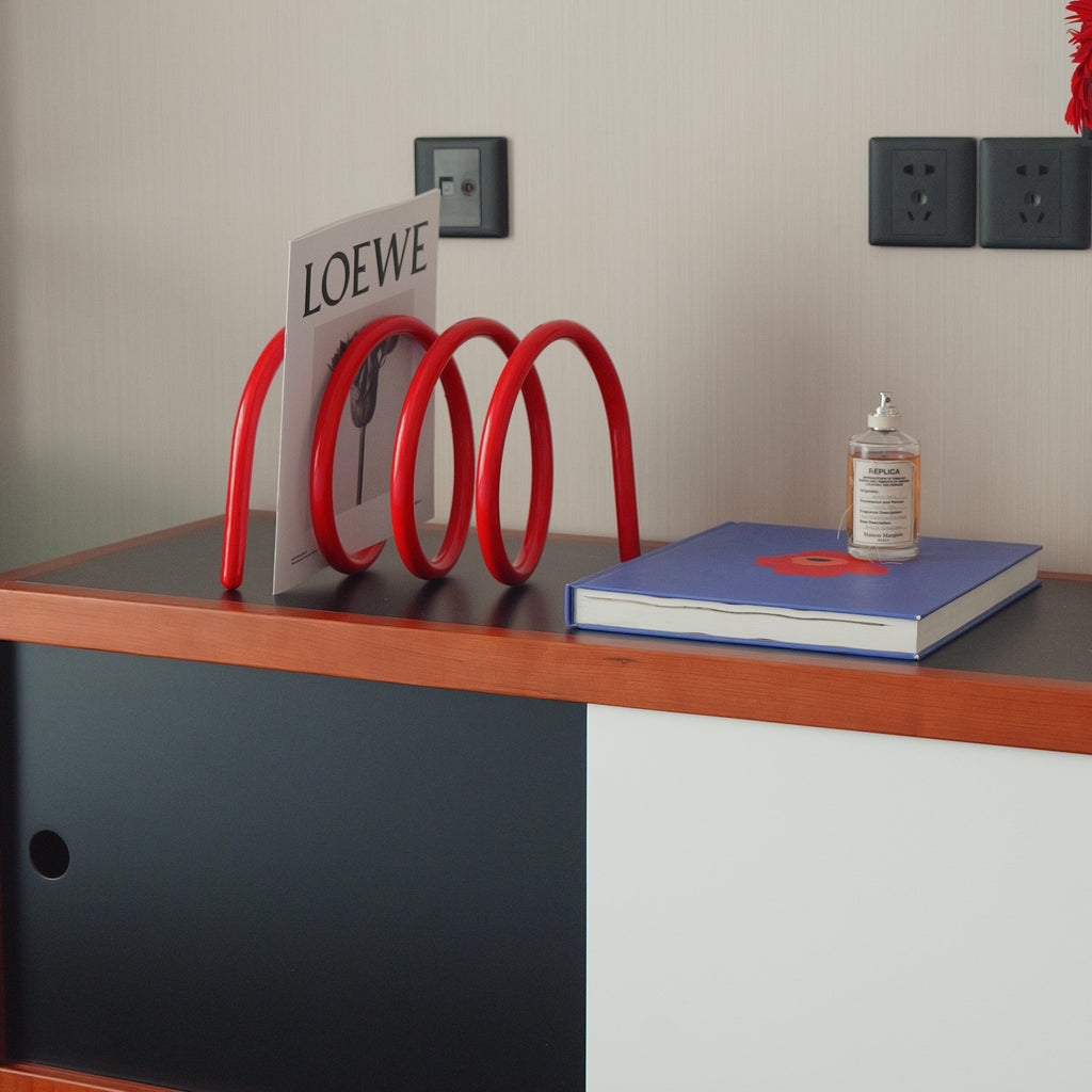 Red spiral spring book holder with smooth glossy finish for organizing and displaying books