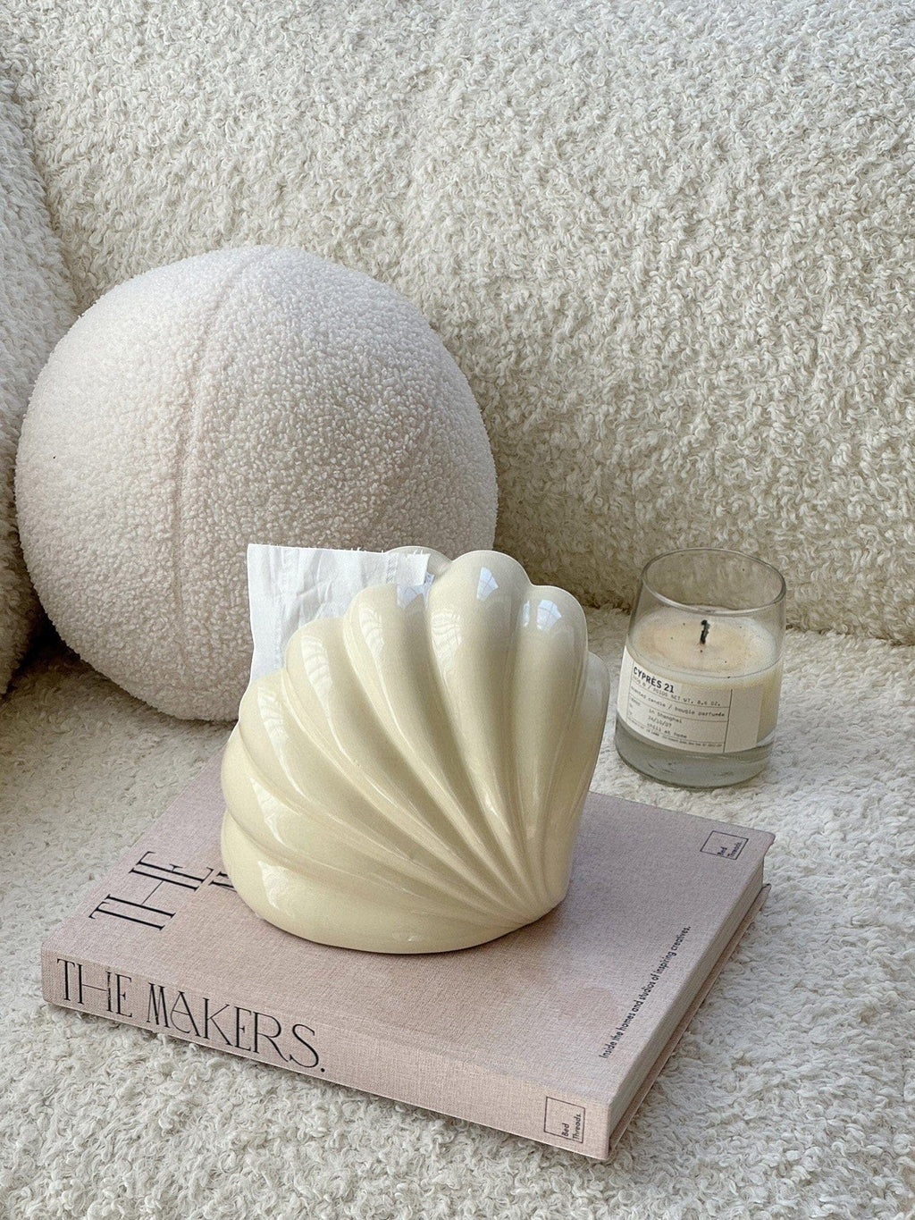 Cream-colored glossy shell tissue holder with smooth curved design for stylish and functional tissue dispensing