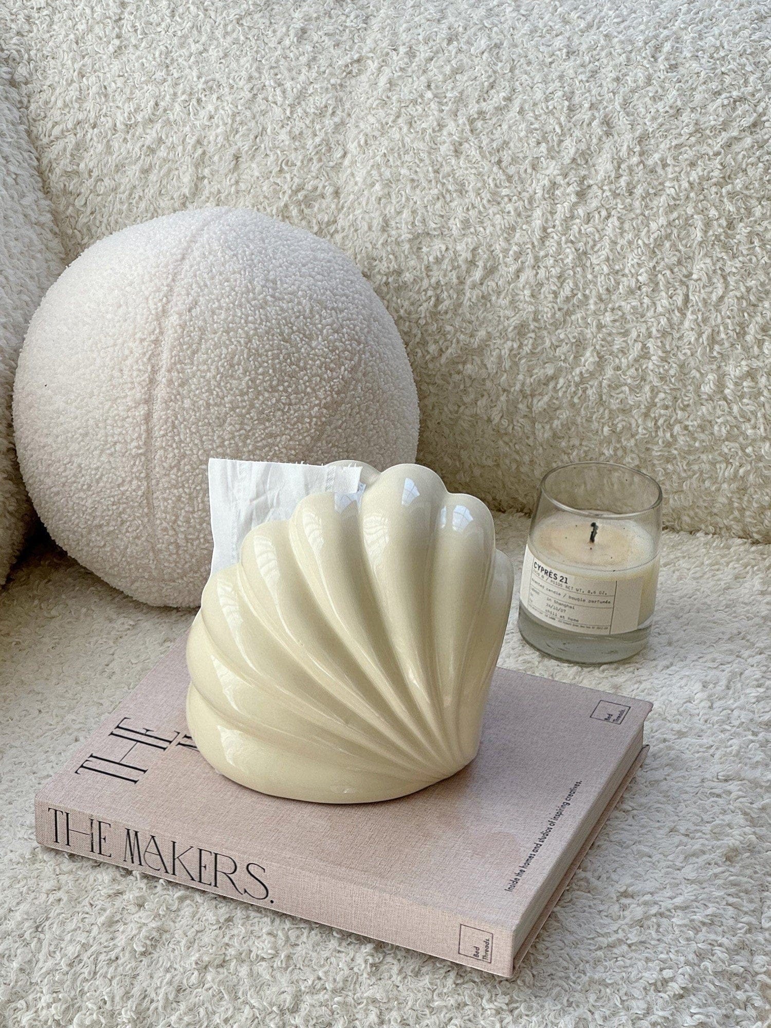 Cream-colored glossy shell tissue holder with smooth curved design for stylish and functional tissue dispensing