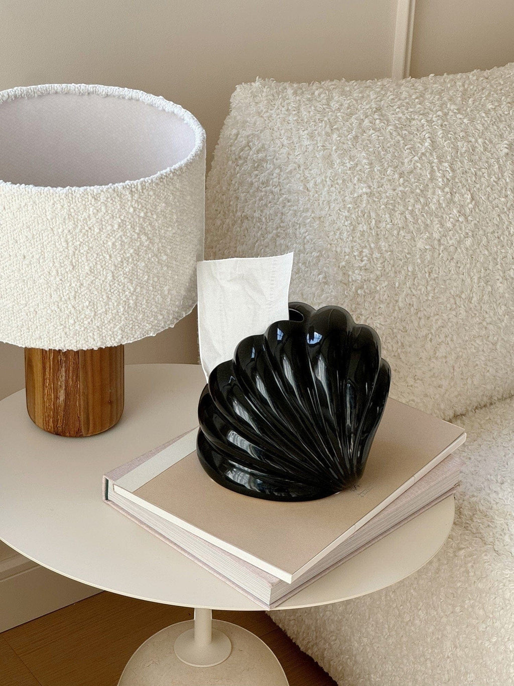 Black glossy shell-shaped tissue holder with sleek ridged design for stylish tissue storage