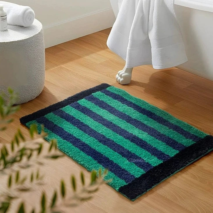 Green retro striped bath mat with plush textured surface in green and navy blue for bathroom use