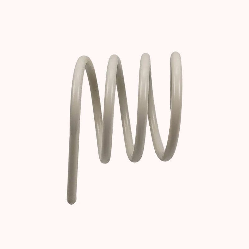 A sleek off-white coiled metal spring with smooth uniform texture used as a spring book holder