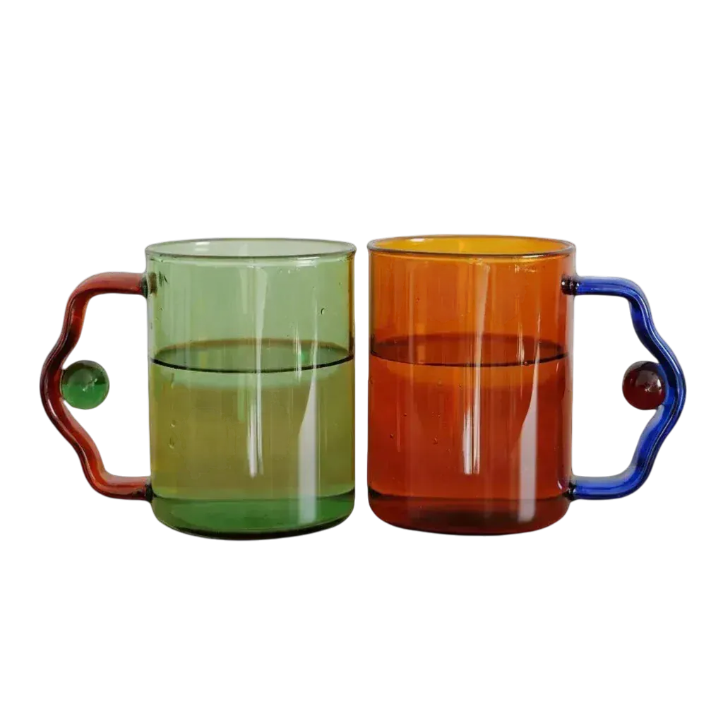 Two translucent glass color block bead mugs in green with red handle and orange with blue handle featuring beaded accents