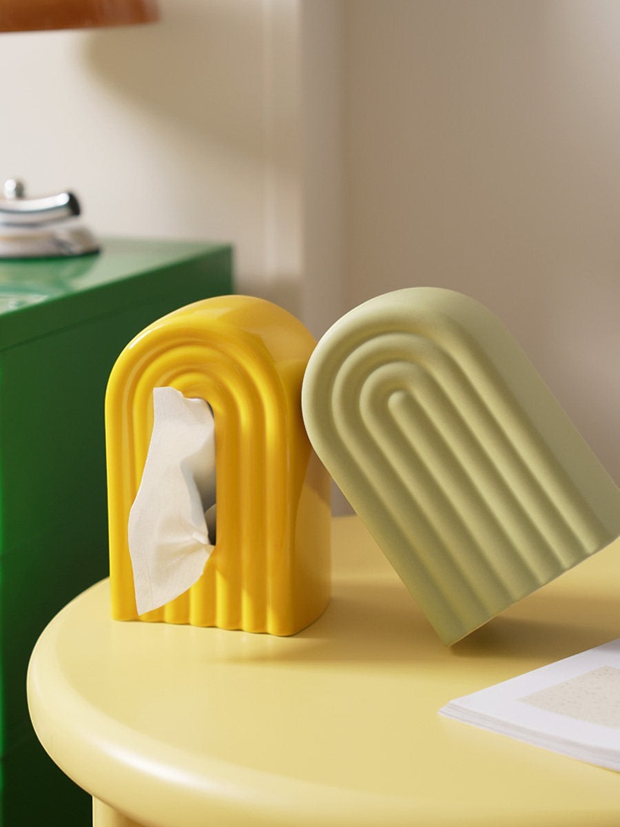 HOMELIVY ceramic arch tissue holders in yellow and sage green with a ribbed, modern design on a yellow table.