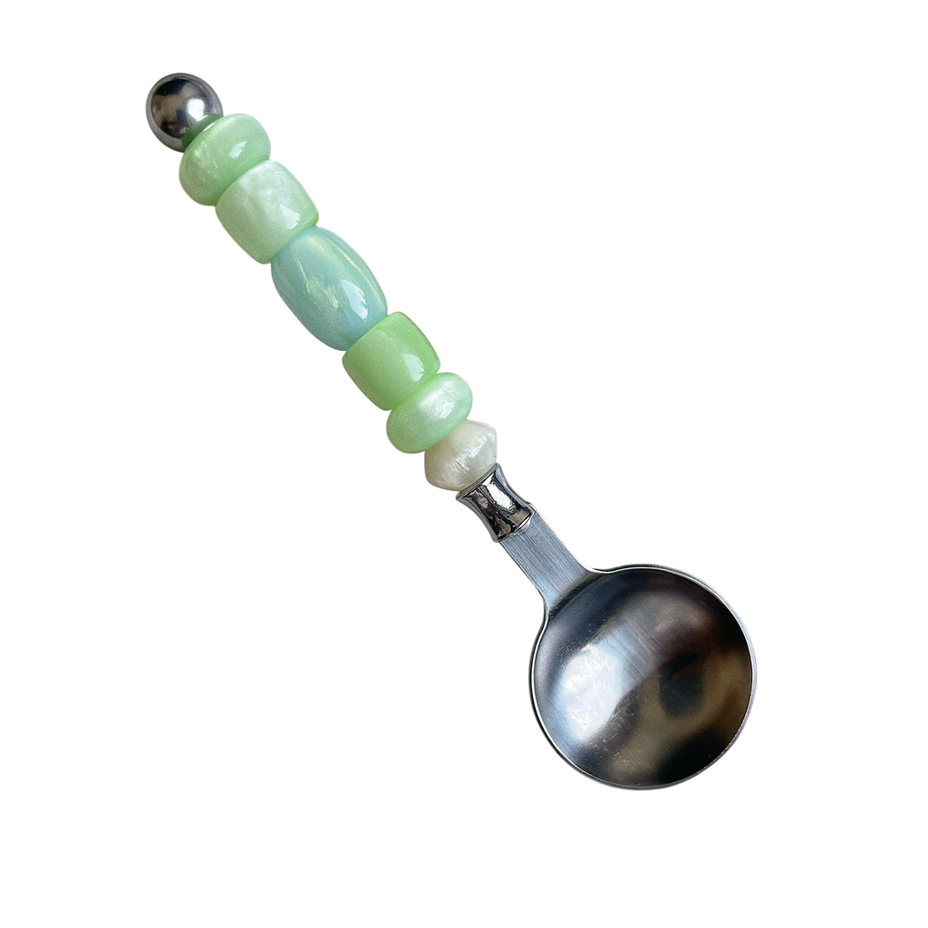 HOMELIVY stainless steel spoon with a decorative handle featuring light green and pearlescent beads.