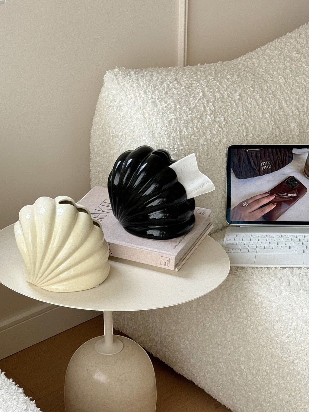 Black glossy shell tissue holder made of durable material with a white paper towel emerging from the top