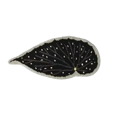 Black leaf-shaped patch with white detailing on a white background