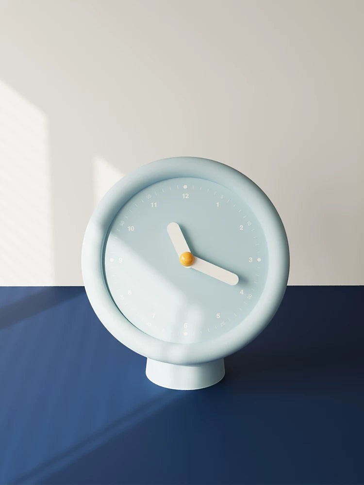 HOMELIVY powder blue minimalist desk clock with white hands and a yellow center on a pedestal base.