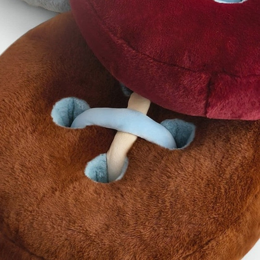 HOMELIVY brown plush cushion designed as a button with blue thread detail and a red cushion on top.