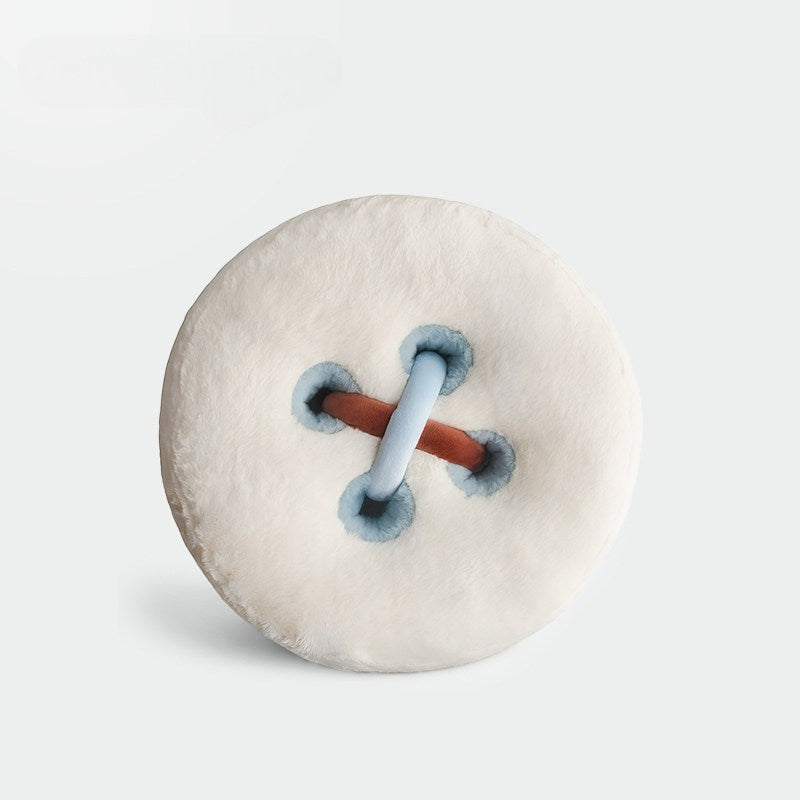 HOMELIVY plush cushion designed as a large white button with blue trim and brown and light blue stitching.