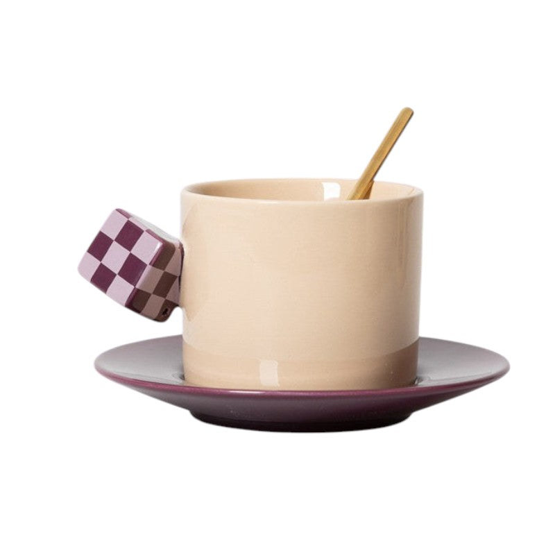 HOMELIVY beige ceramic mug with a purple checkerboard cube handle and matching purple saucer with a gold spoon