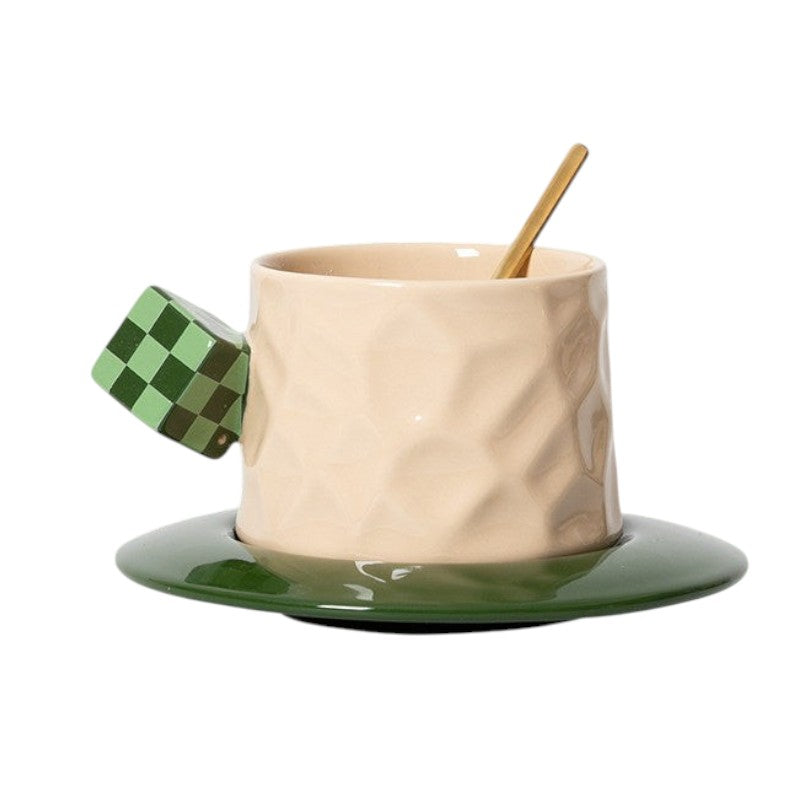 HOMELIVY ceramic mug with a beige faceted body, green checkerboard cube handle, and matching green saucer with spoon.