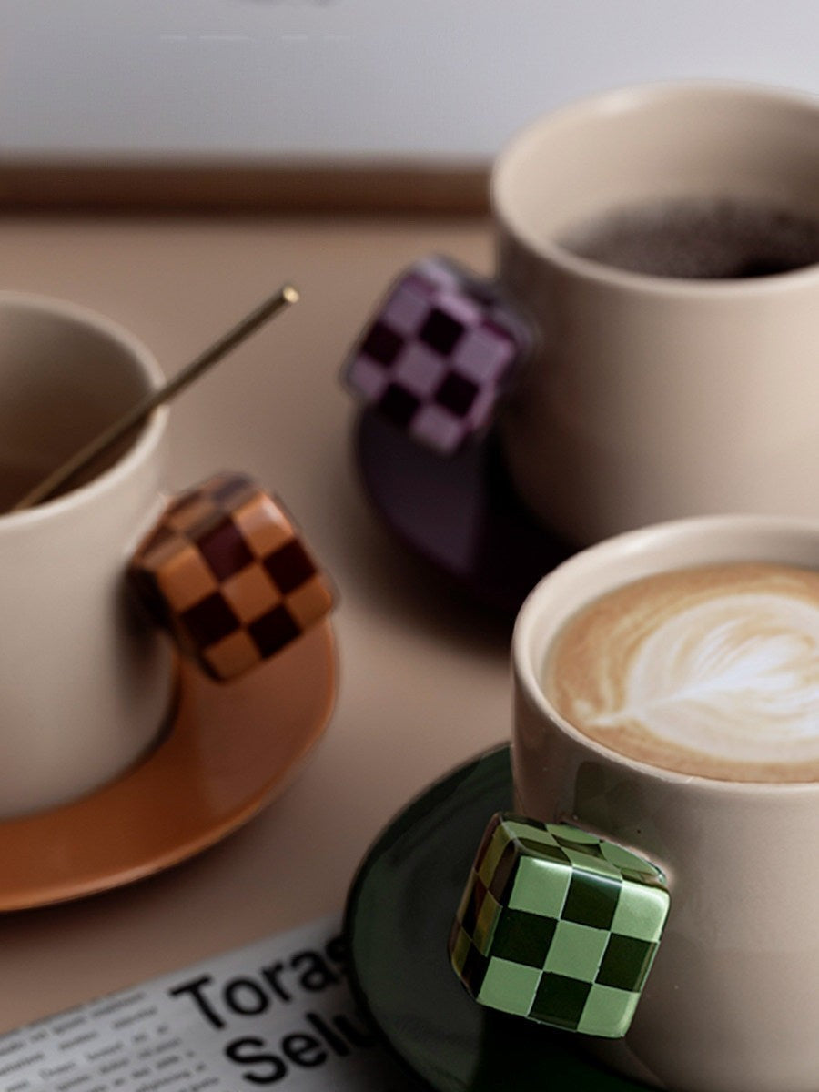 HOMELIVY ceramic coffee mugs with unique cube-shaped checkerboard handles in green, purple, and brown on saucers.