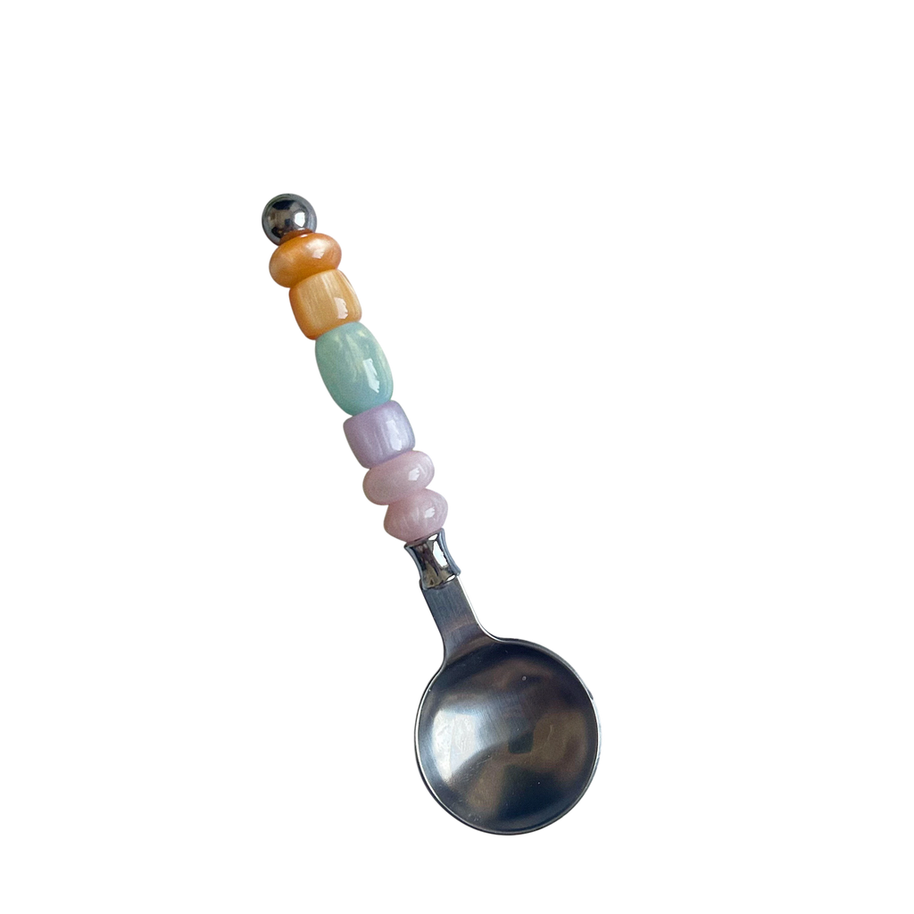 HOMELIVY colorful beaded spoon with pastel resin beads on a stainless steel handle against a black background.