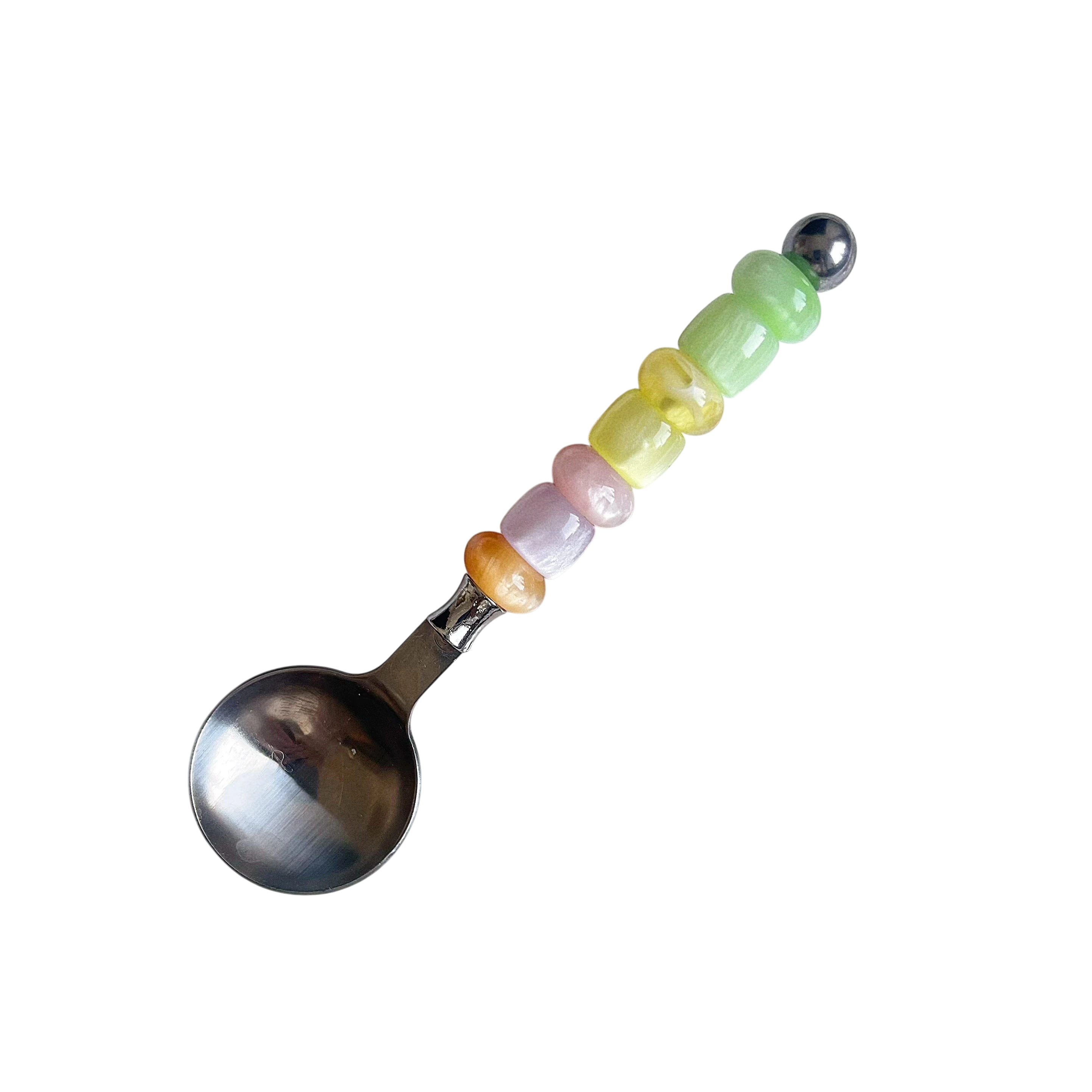 HOMELIVY stainless steel spoon featuring a handle decorated with colorful pastel beads in a vertical row.