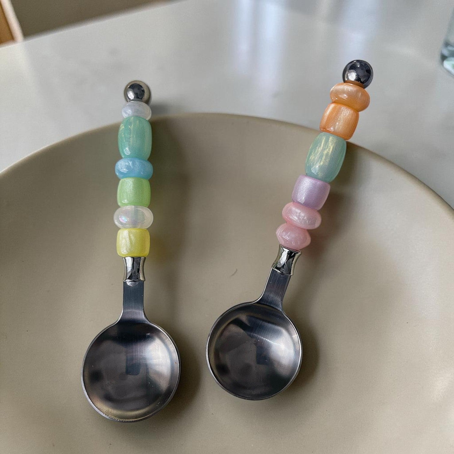 HOMELIVY stainless steel spoons with decorative pastel beaded handles in a variety of iridescent colors.