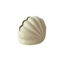 Cream-colored ceramic seashell-shaped shell tissue holder with glossy finish and subtle ridges