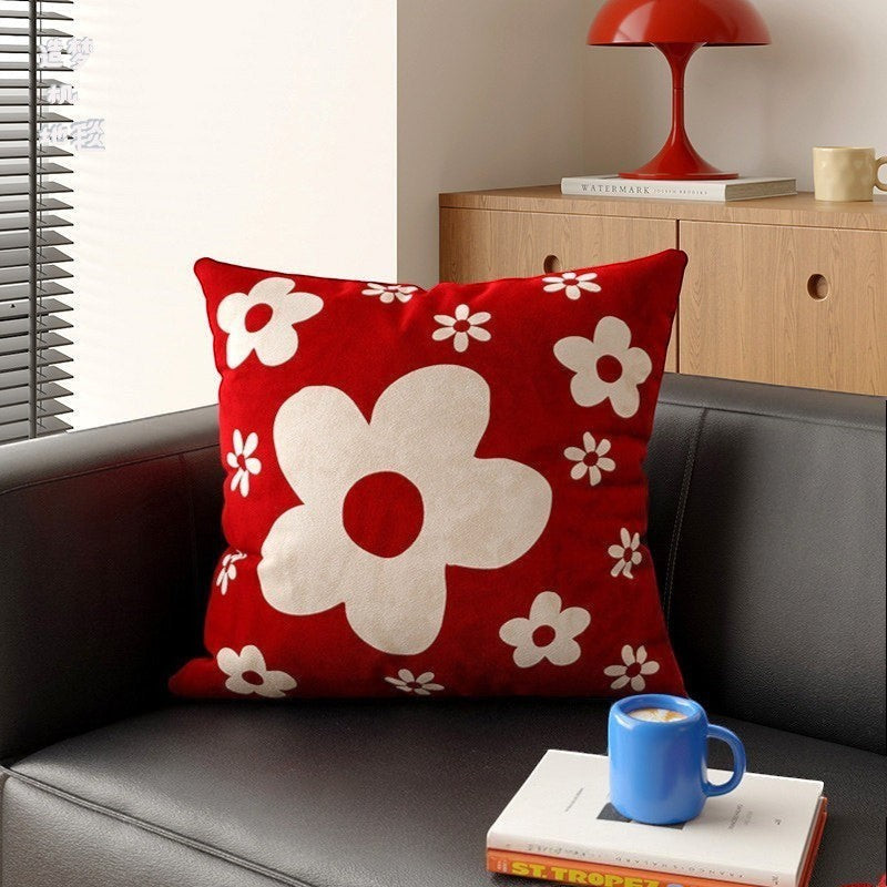 HOMELIVY red throw pillow with white daisy flower pattern on a black leather sofa in a modern living room
