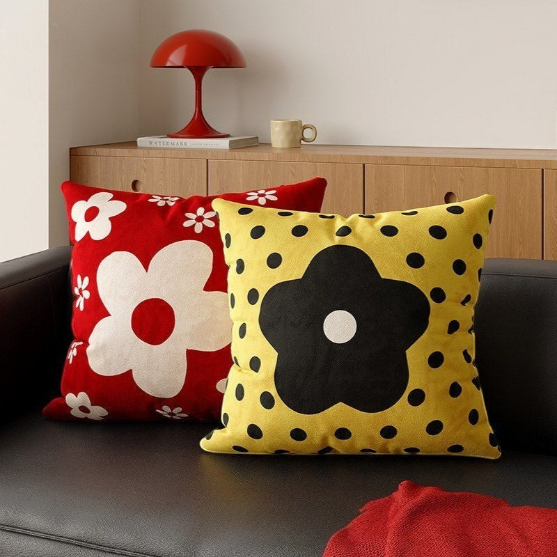 HOMELIVY decorative throw pillows with red daisy floral and yellow polka dot patterns on a black sofa.
