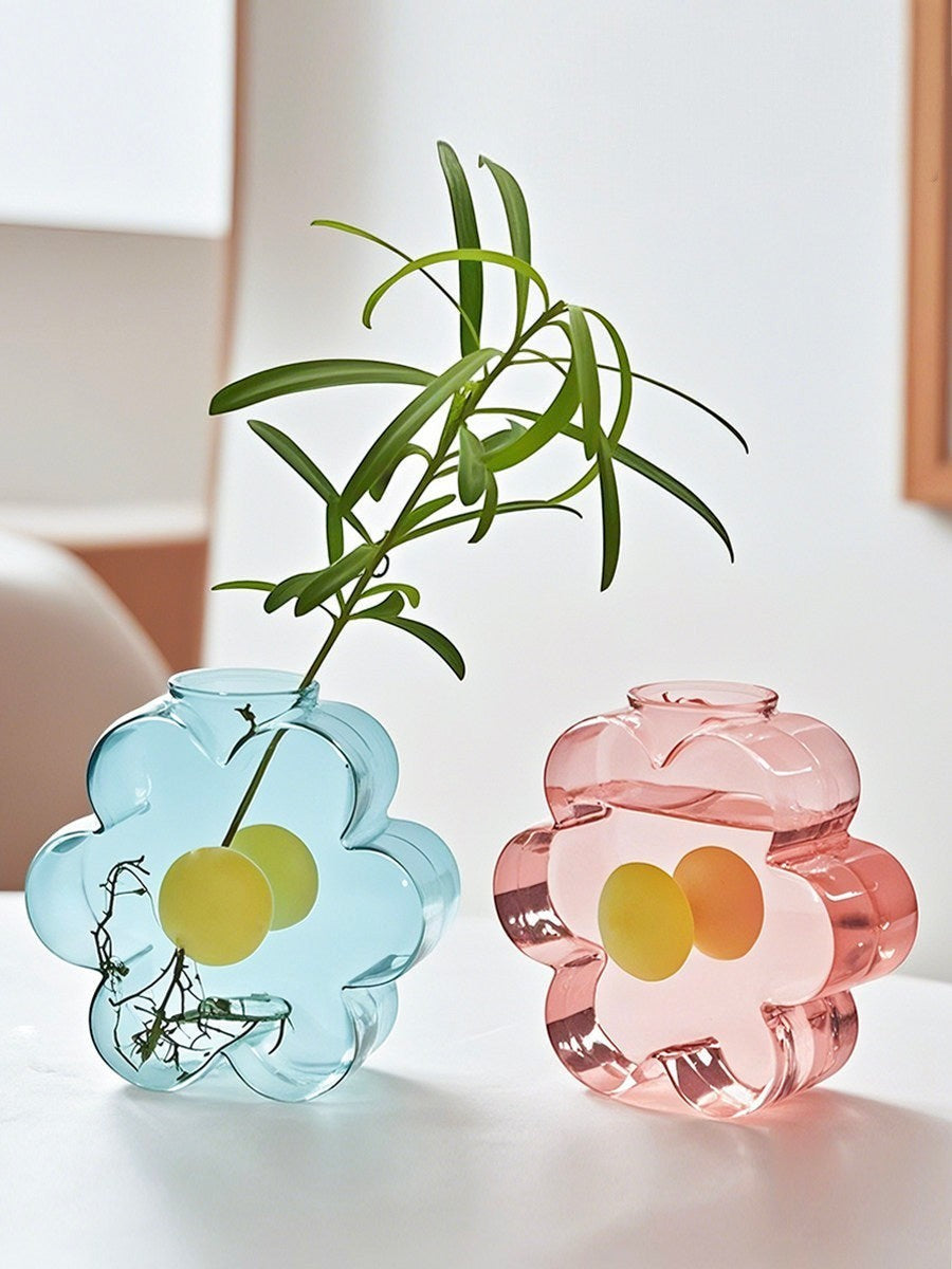 HOMELIVY flower-shaped glass vases in pastel blue and pink with rounded silhouettes on a white table.