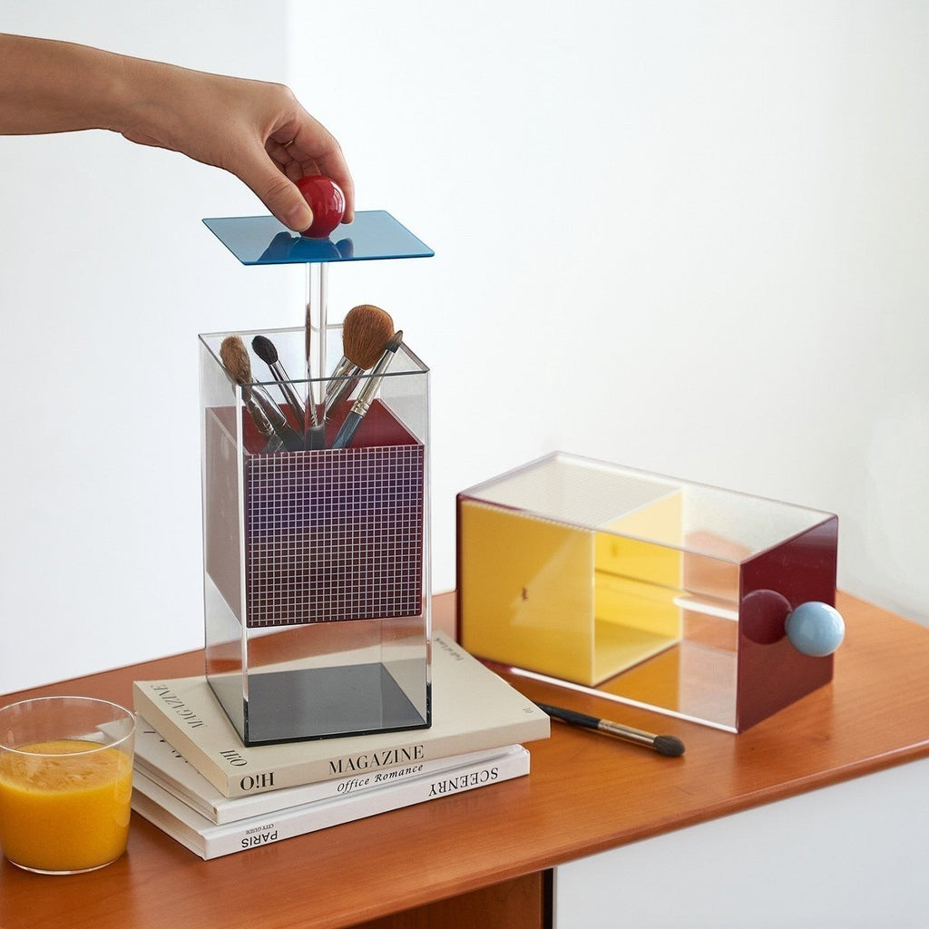 HOMELIVY Quirky Memphis acrylic brush holder with geometric design in blue, red, and pink. Holds makeup brushes.