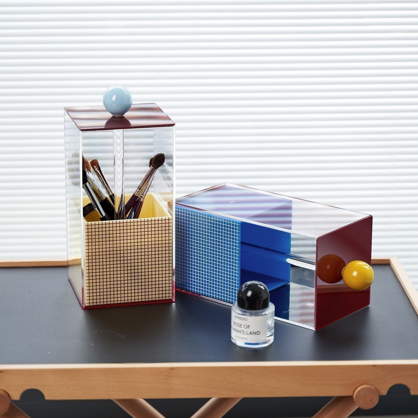 HOMELIVY Quirky Memphis acrylic brush holder with geometric design in blue, yellow, red, and pink. Features a light blue sphere accent on top.