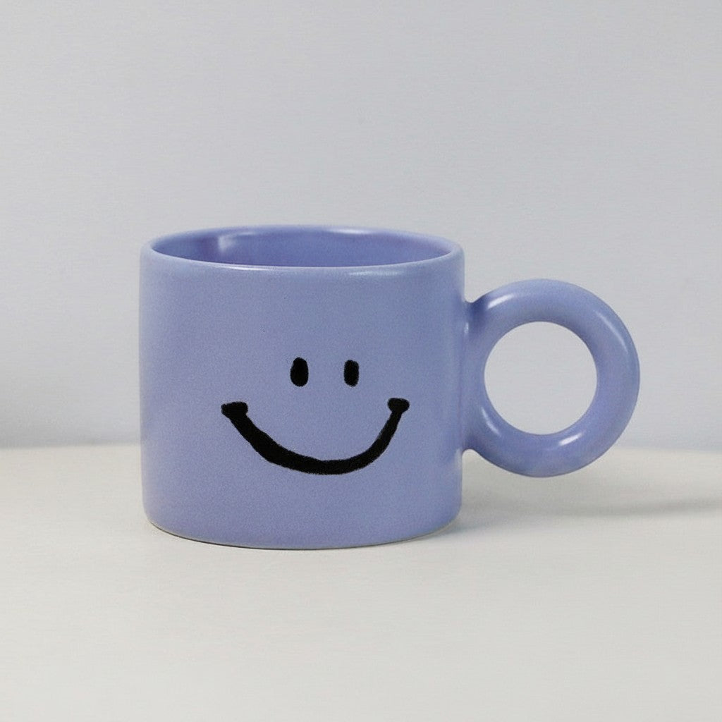 HOMELIVY light purple ceramic mug featuring a black hand-painted smiley face and a round circular handle.