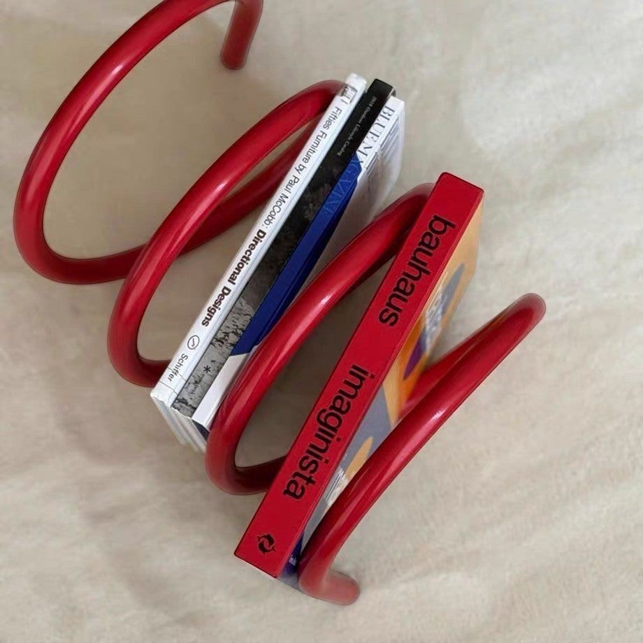 HOMELIVY red spiral spring book holder displaying magazines and books on a neutral surface.