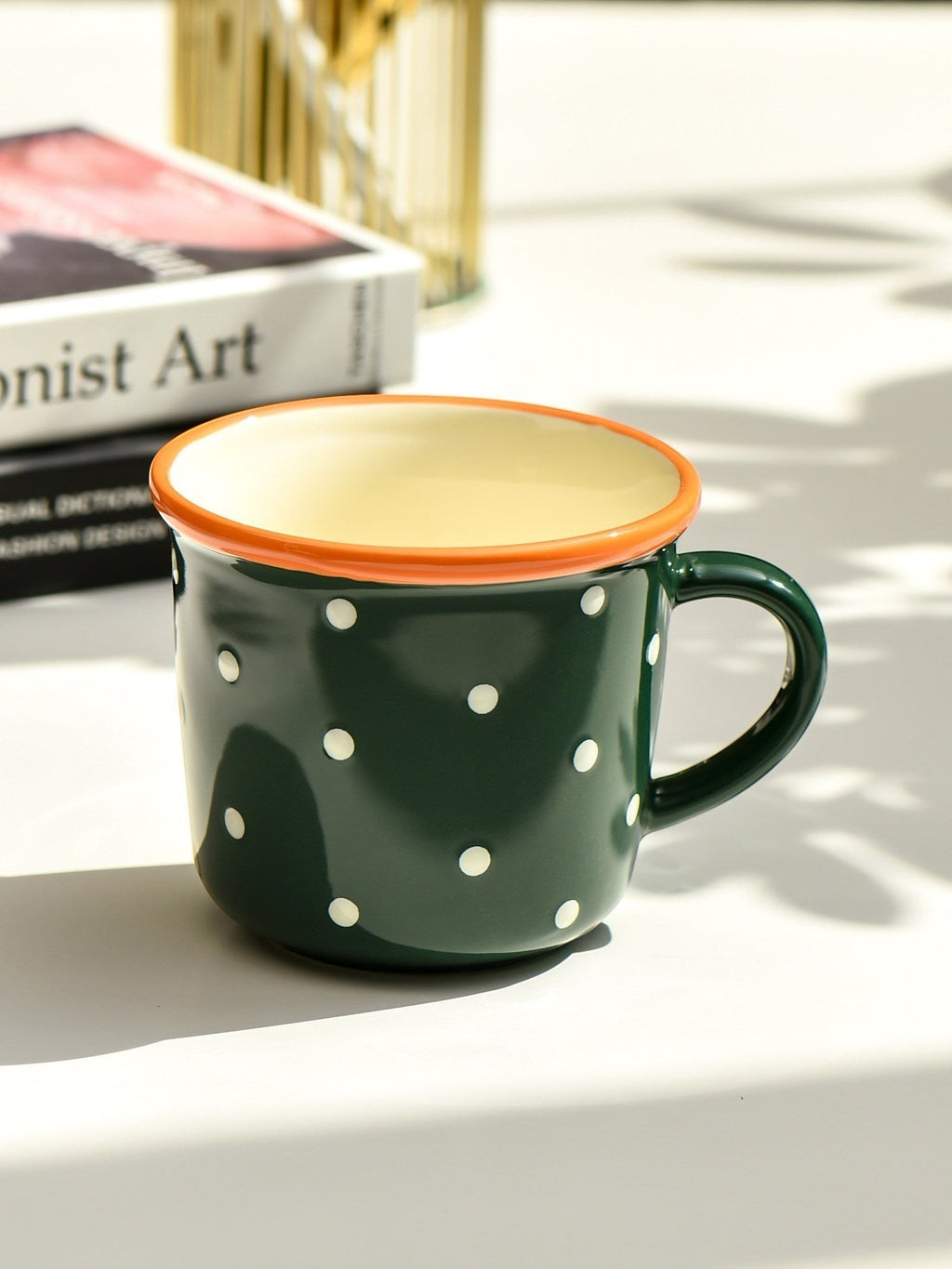 HOMELIVY retro ceramic mug in dark green with white polka dots and a glossy orange contrast rim.