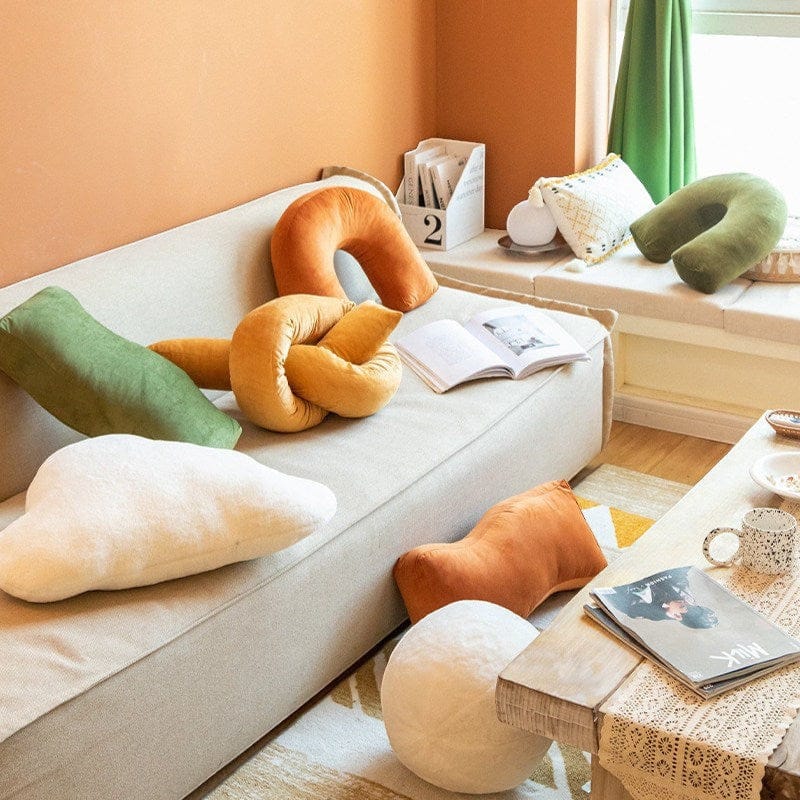 HOMELIVY sculptural velvet cushions in burnt orange, gold, olive, and cream. Arch, knot, bolster, and cloud shapes.