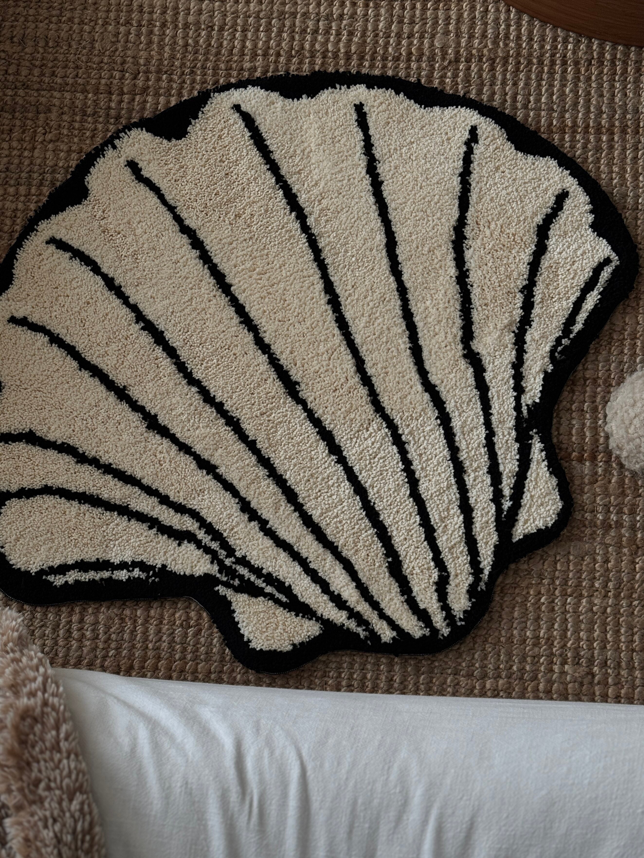 HOMELIVY cream shell-shaped rug with black scallop trim and ribbed detail. Textured shag.